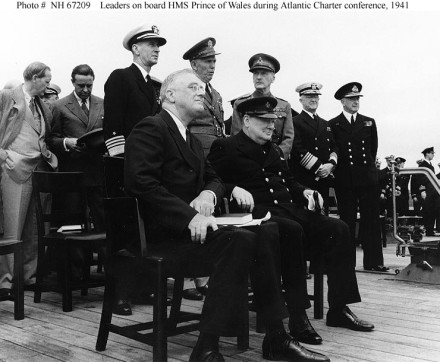 Conference leaders during Church services on the after deck of HMS Prince of Wales, in Placentia Bay, Newfoundland, during the Atlantic Charter Conference. President Franklin D. Roosevelt (left) and Prime Minister Winston Churchill are seated in the foreground. Standing directly behind them are Admiral Ernest J. King, USN; General George C. Marshall, U.S. Army; General Sir John Dill, British Army; Admiral Harold R. Stark, USN; and Admiral Sir Dudley Pound, RN. At far left is Harry Hopkins, talking with W. Averell Harriman.