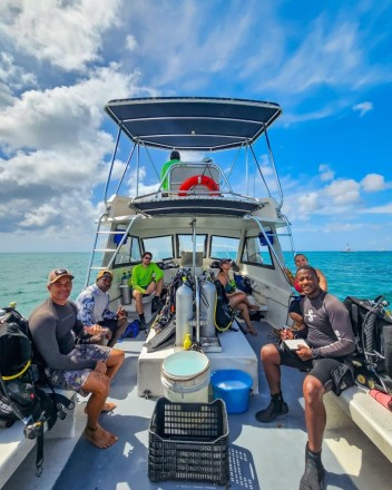 Een foto van een groep duikers op een boot.