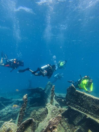 An underwater photograph of a group of divers at the wreck.