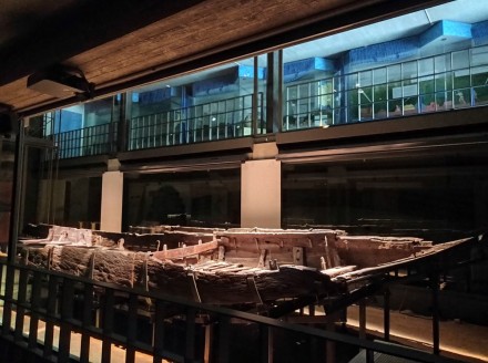 A photo of the remains of a barge in a museum.