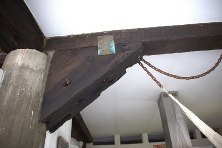 A photo of an old piece of ship's wood in the roof of a house.