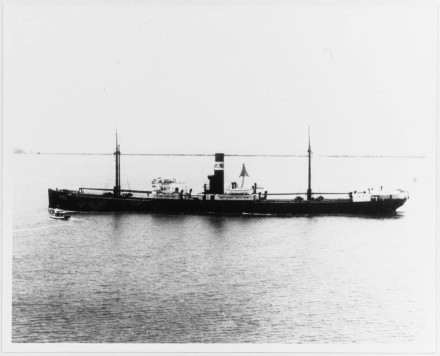 A black and white photo of a steamer sailing, taken from the air.